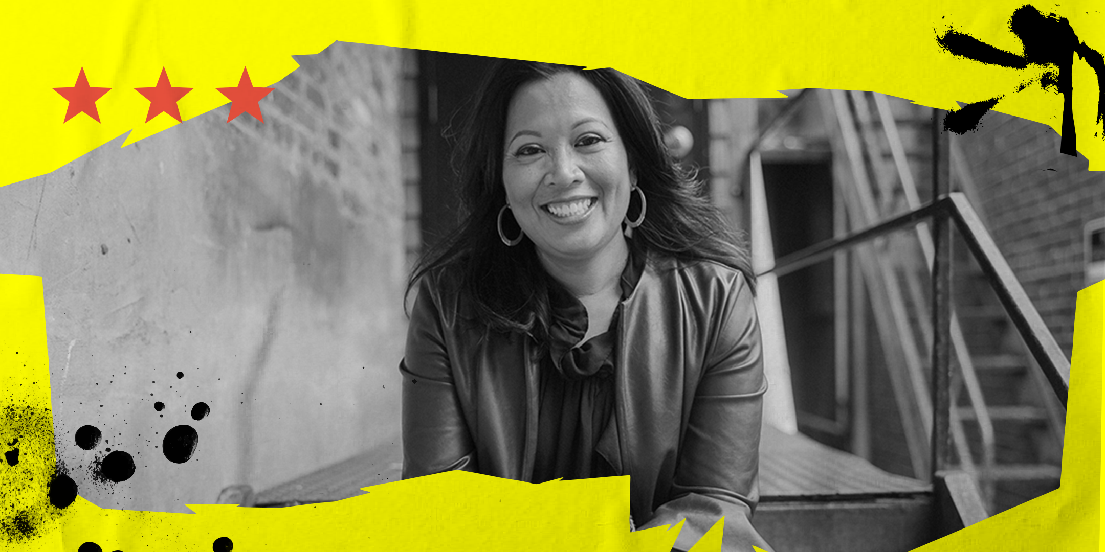 Photo of Rhea Vaflor, a mature, brown skin Filipinx female with medium-length dark hair who is seated on a stair, wearing a dark blue top and burgundy colored jacket, smiling, and looking directly at the camera. while.