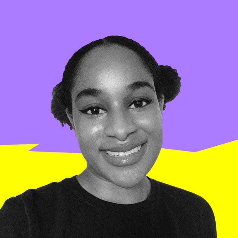 An African American woman with afro puffs, smiling at the camera.