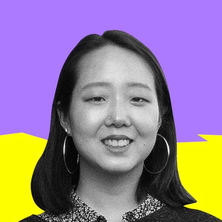 A young, smiling, Korean-American woman with big hoop earrings.